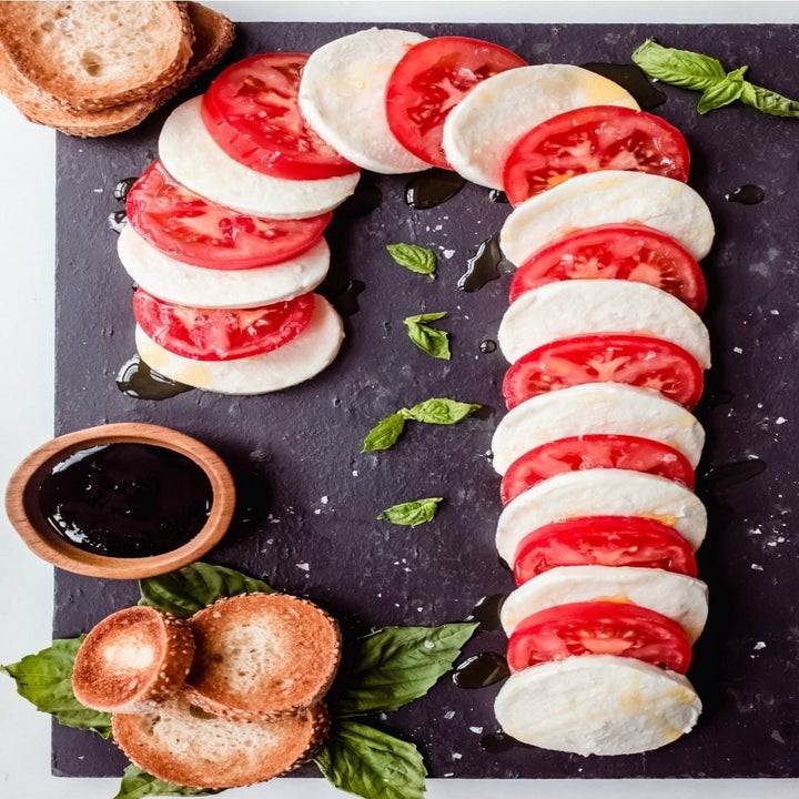 Caprese and tomatoes, sliced and assembled in a candy cane shape.