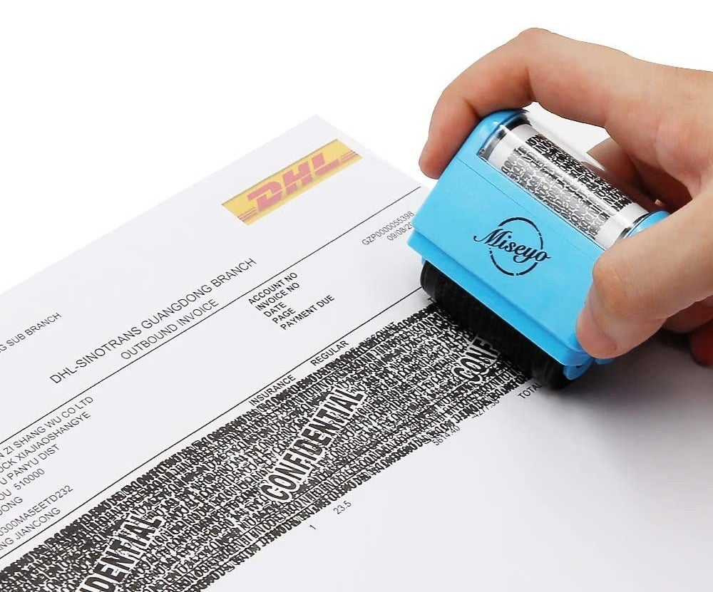 person rolling the stamp across a piece of paper 