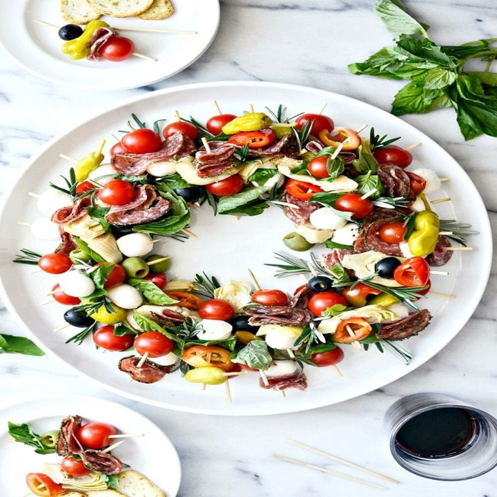 A handful of antipasto skewers organized in a circle to create a wreath.