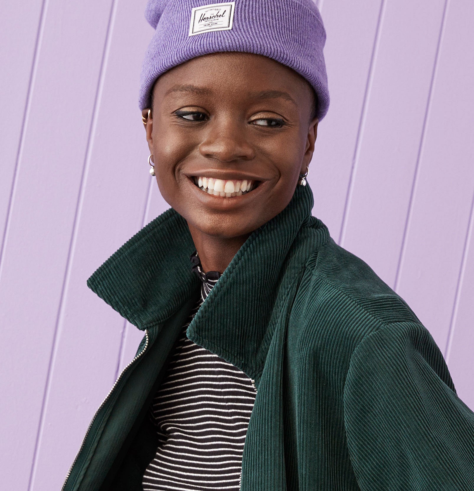 A person wearing the Herschel beanie and smiling
