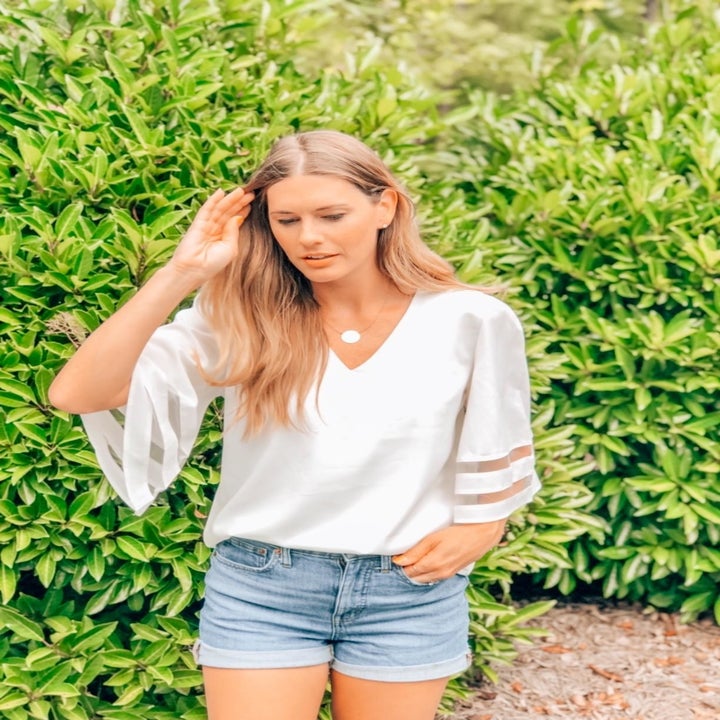 Reviewer wearing the v-neck blouse in white