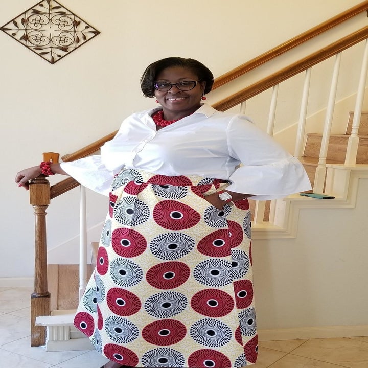 A different reviewer wearing the skirt in a white, red, and grey circular pattern