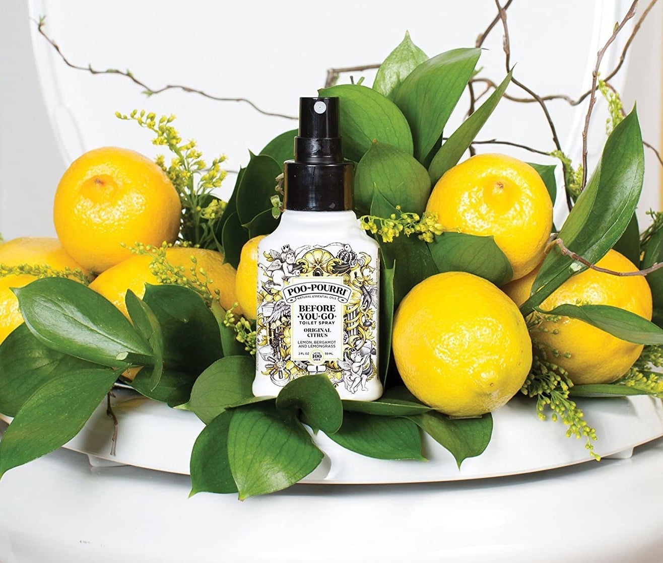 Bottle of poo-pourri next to lemons on plate