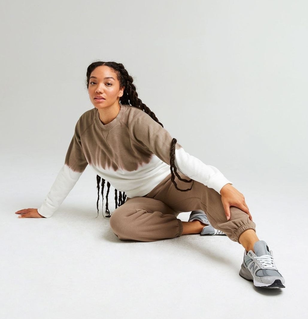 Model wearing the sweatshirt in a brown and white tie-dye and brown sweatpants