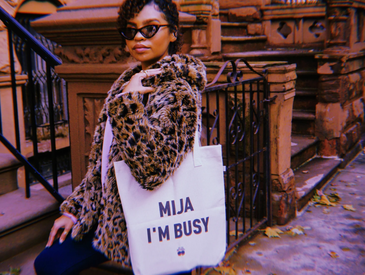 A women on a brownstone stoop wearing a leopard print coat carrying the tote