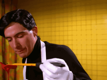 A GIF of a man licking a ladle full of sauce.