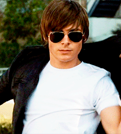 Zac Efron putting on his leather jacket and nodding. 