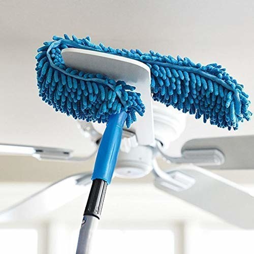A ceiling fan being cleaned using a flexible mop