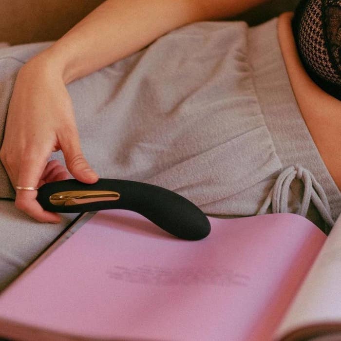A model holding the black vibrator with a slightly curved tip