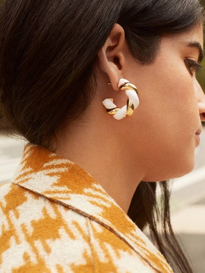 model wearing the  gold and white chunky twist hoops