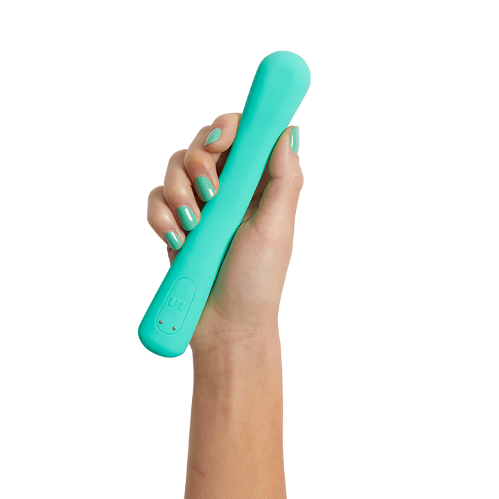 A hand holding a slim, pole-shaped vibrator