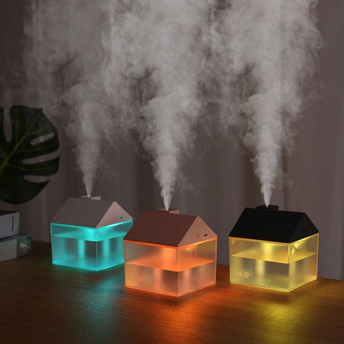 three house-shaped humidifiers with steam escaping from the house chimney
