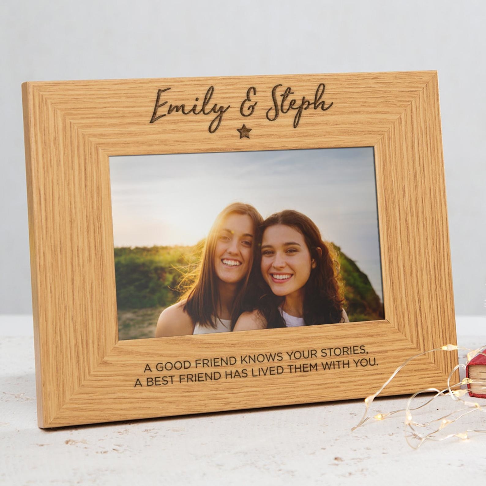 a rectangular wooden picture frame with the names &quot;Emily and Steph&quot; at the top and a message on the bottom saying, &quot;A good friend knows your stories. A best friend has lived them with you.&quot;