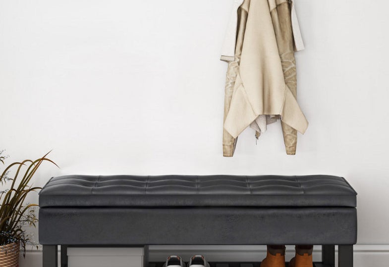 a black leather storage bench with a shelf underneath for shoes