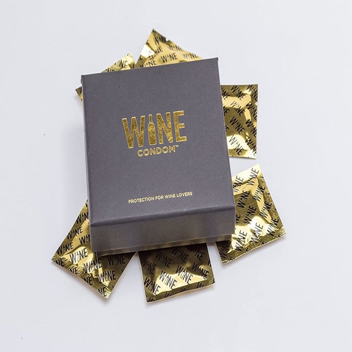 the box of wine condoms with various packets of the wine condoms surrounding it