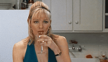 Samantha Jones chugging a glass of wine