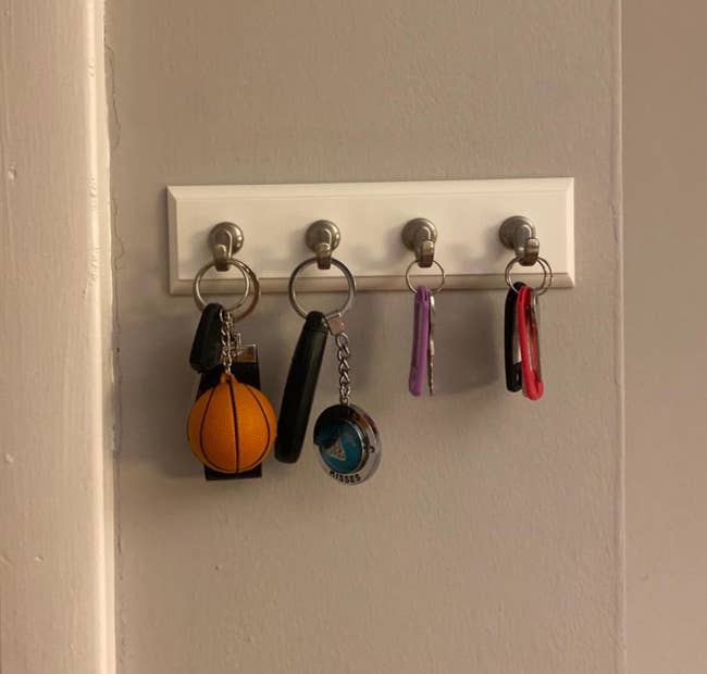 a white rectangular with silver hooks and keys hanging from it 