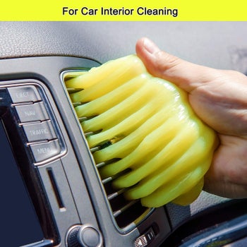 a person using the cleaning gel to clean their car vent