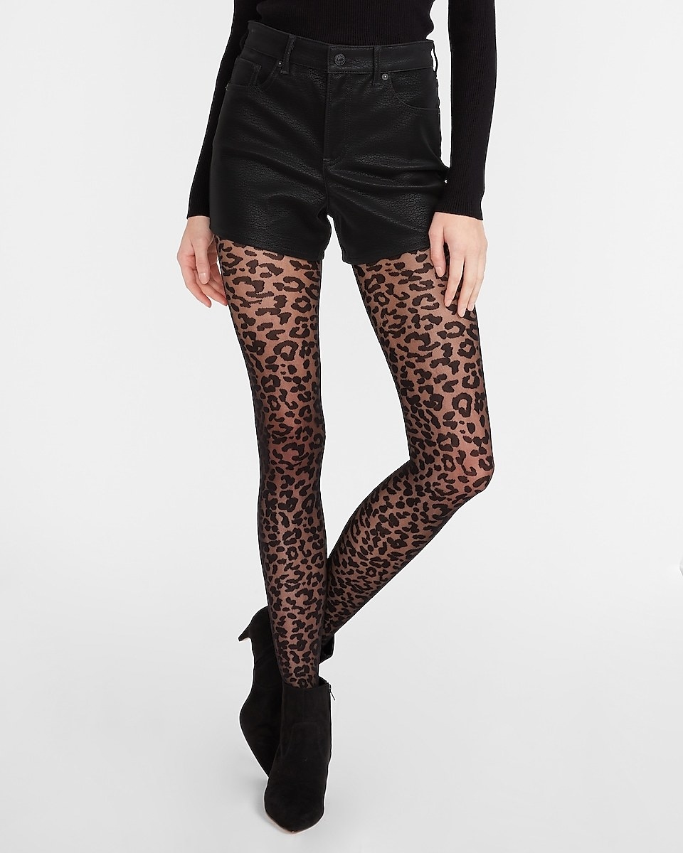 Model wearing the black leopard tights with faux leather shorts