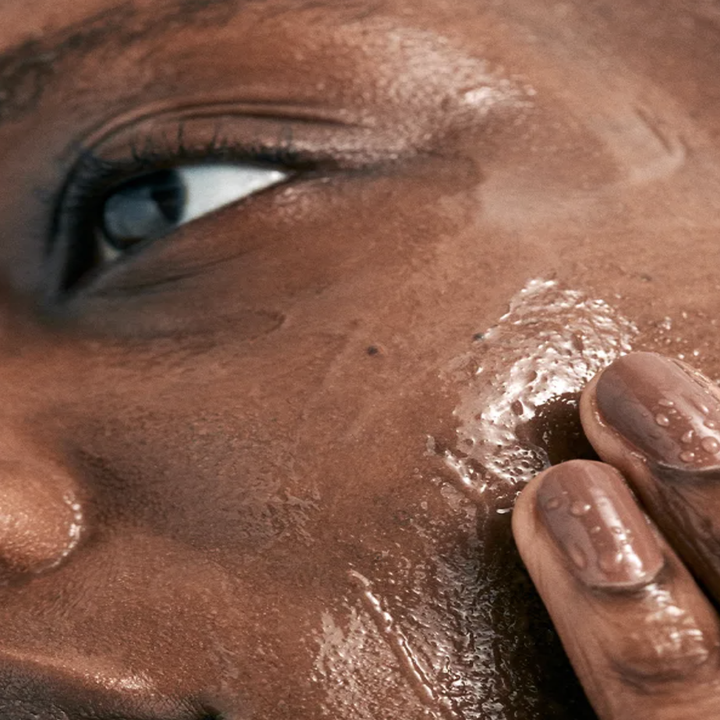a model applying the cleanser to their face