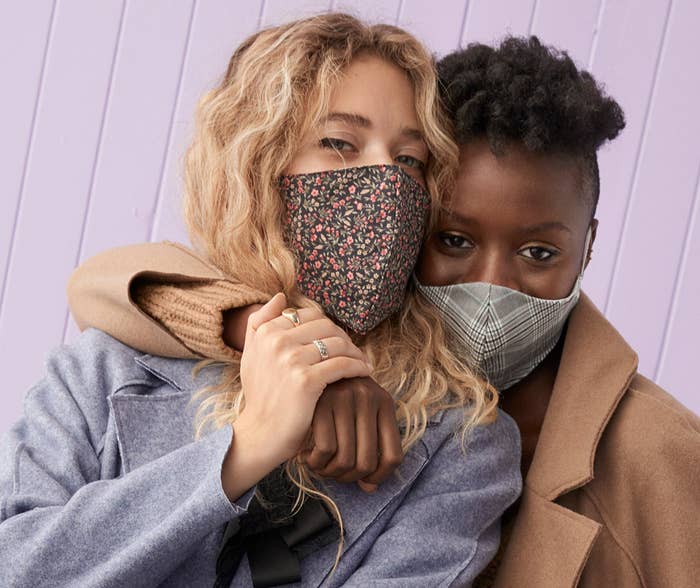Two people wearing patterned masks 