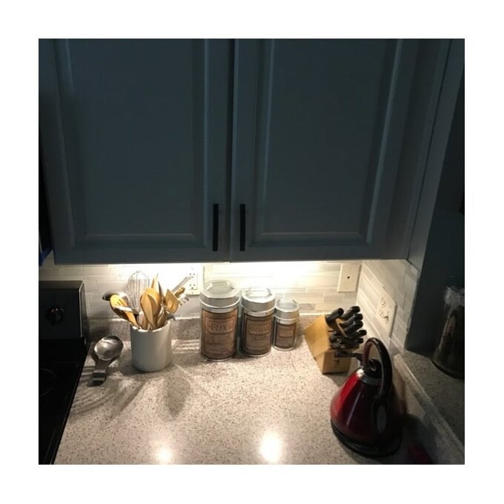 Reviewer's cabinets with only the under-cabinet lights on, highlighting the display beneath