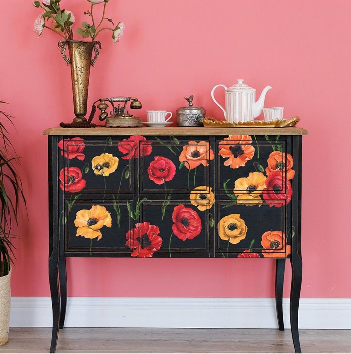 Black sideboard covered in red, yellow, and orange illustrated poppy flower decals