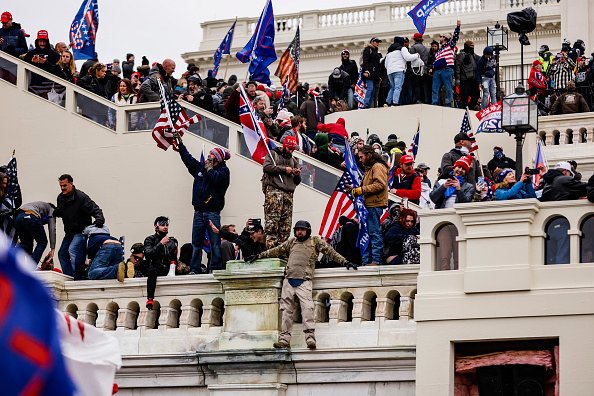 Insurrectionists overrun the steps outside the Capitol while waving US flags and Trump flags