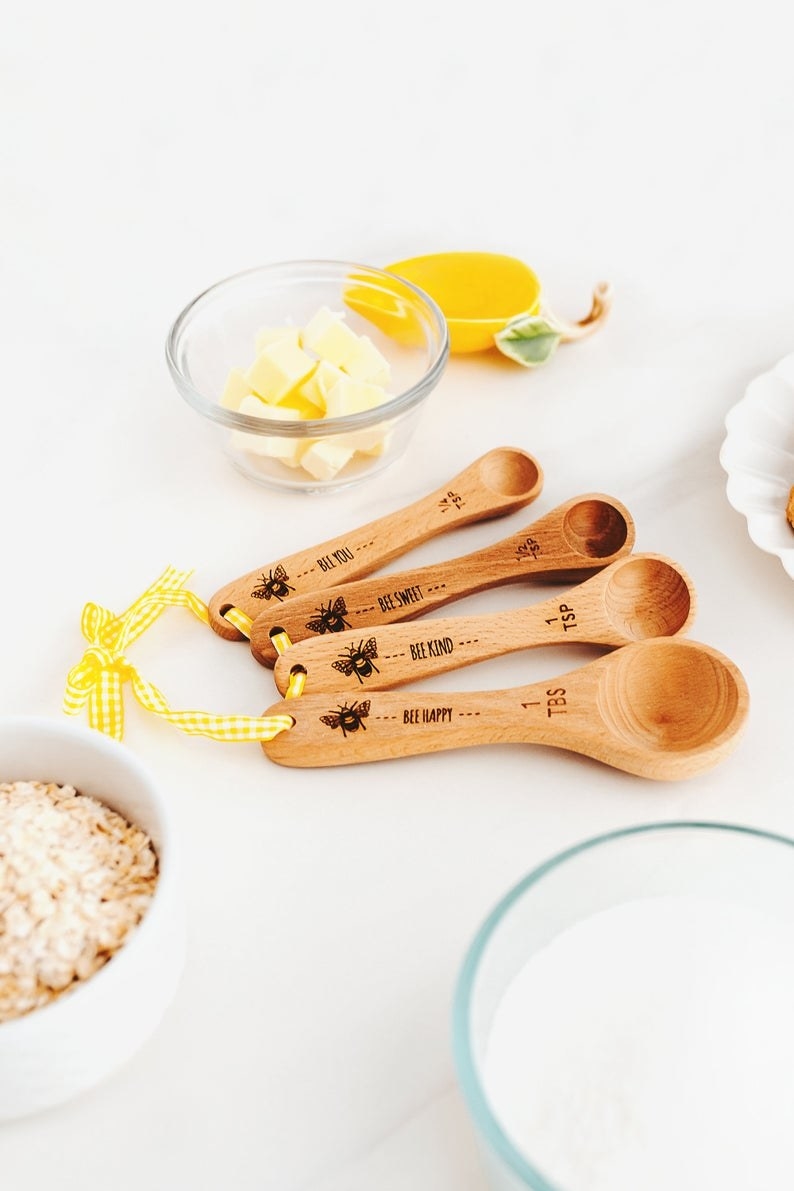 Wooden measuring spoons that say &quot;Be Kind&quot; with a bee design on the front