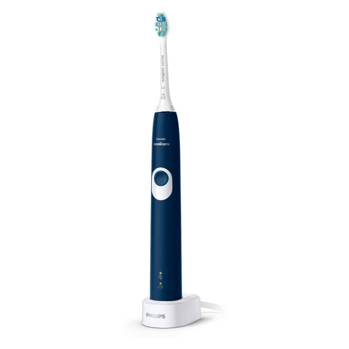 The toothbrush in blue, on its charging base