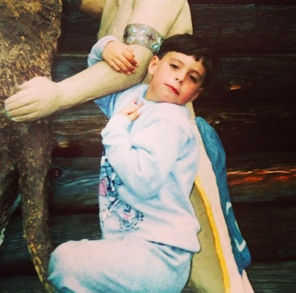 a child posing with a statue