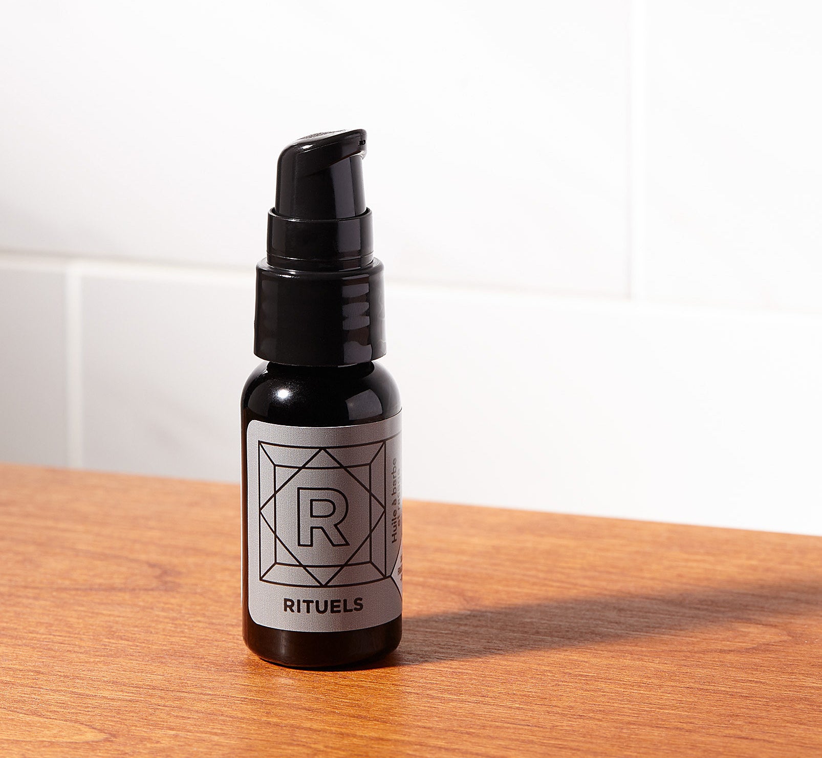 The beard oil in a dark container on a low table