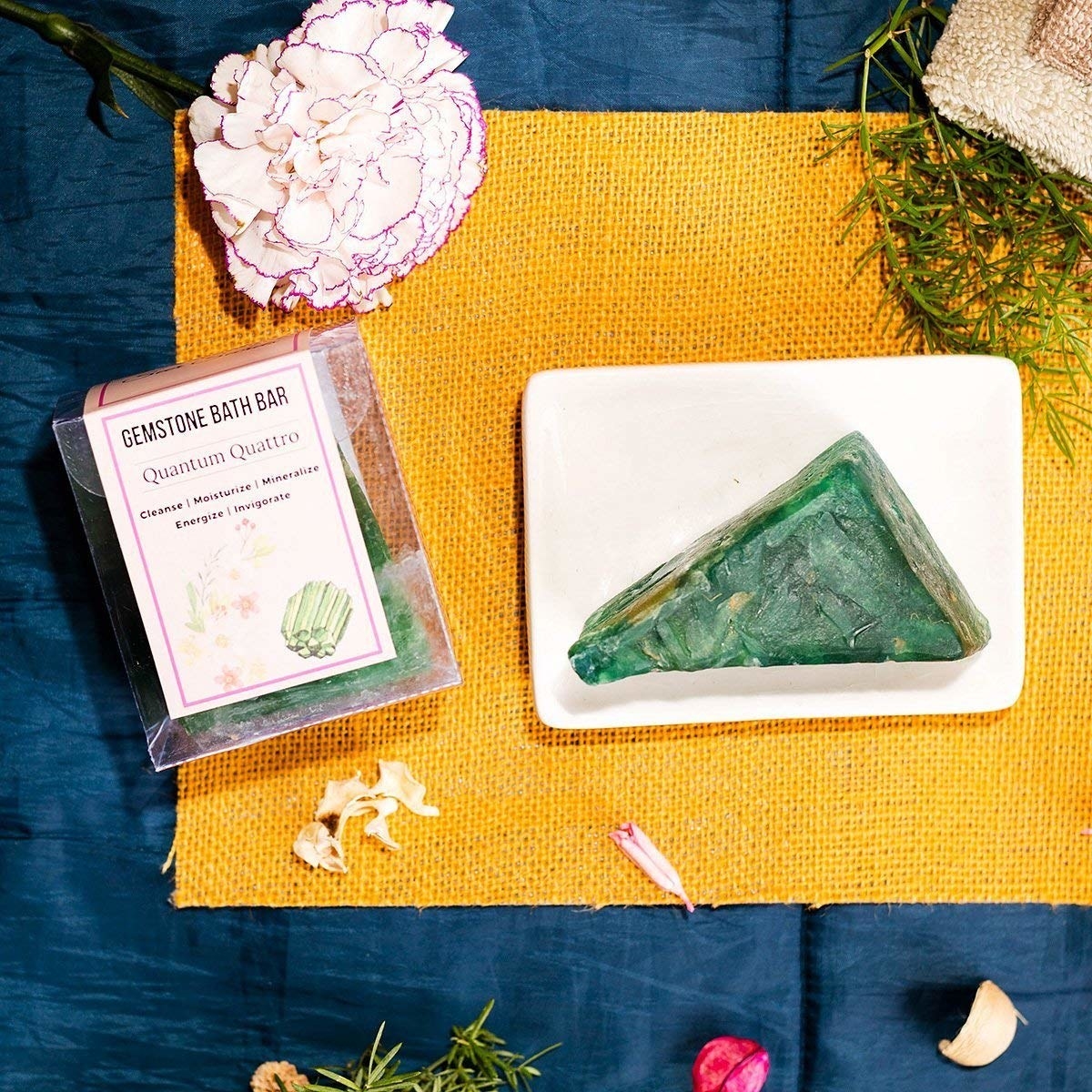 A gemstone soap bar next to a yellow cloth 