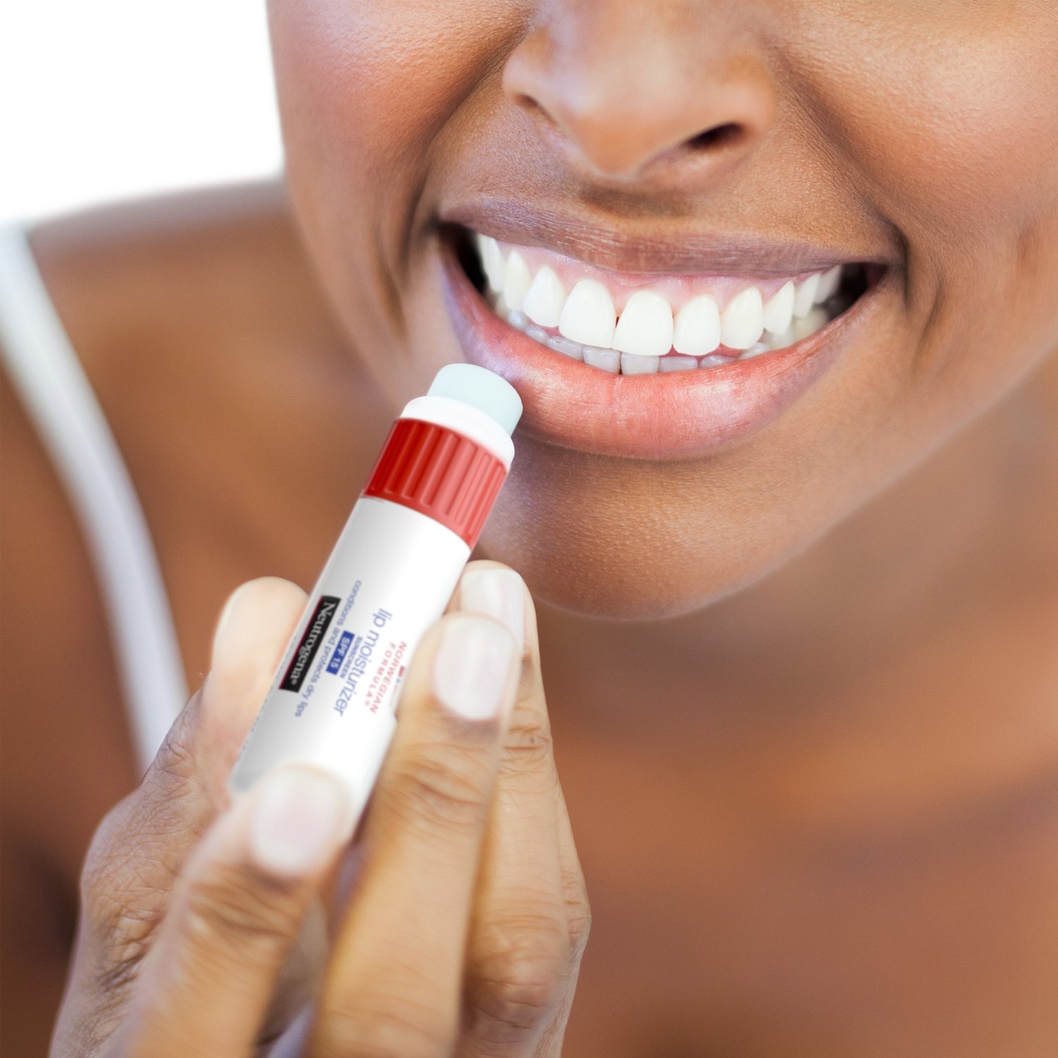 The balm uncapped and placed against a model's lip