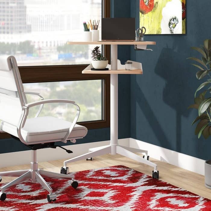 the ebern designs cooperton height adjustable standing desk in the corner of a living space