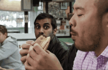 Aziz Ansari and David Chang eating at a restautant.
