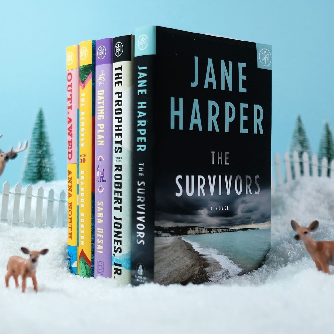 five different books stacked up next to each other in a snow scene