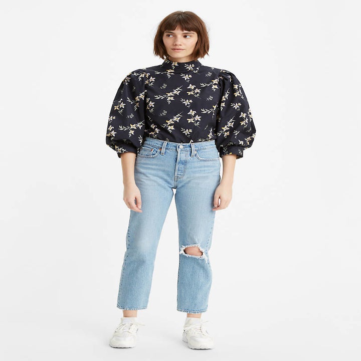 Front view of a model wearing the jeans in tango fray light wash