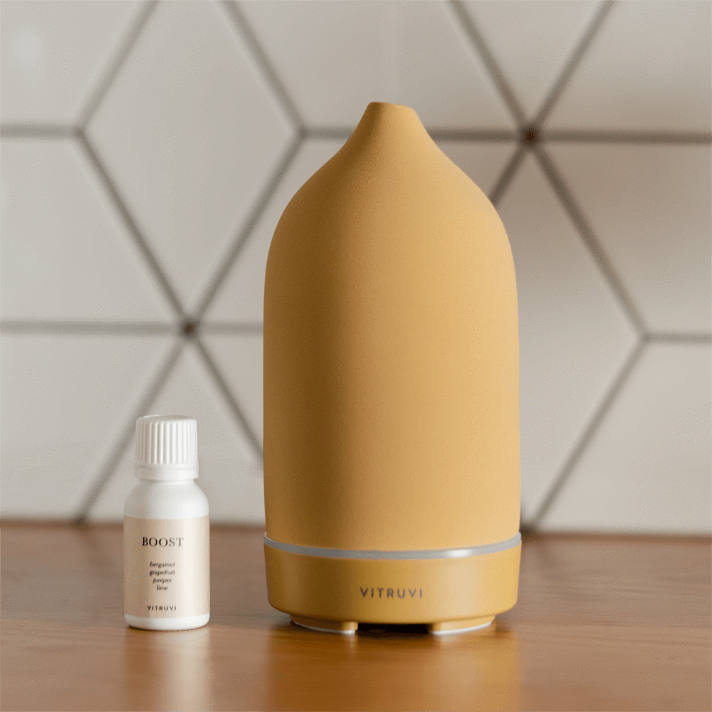 a yellow matte stone diffuser next to a bottle of essential oils
