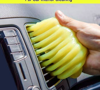 a person using the cleaning gel to clean their car vent