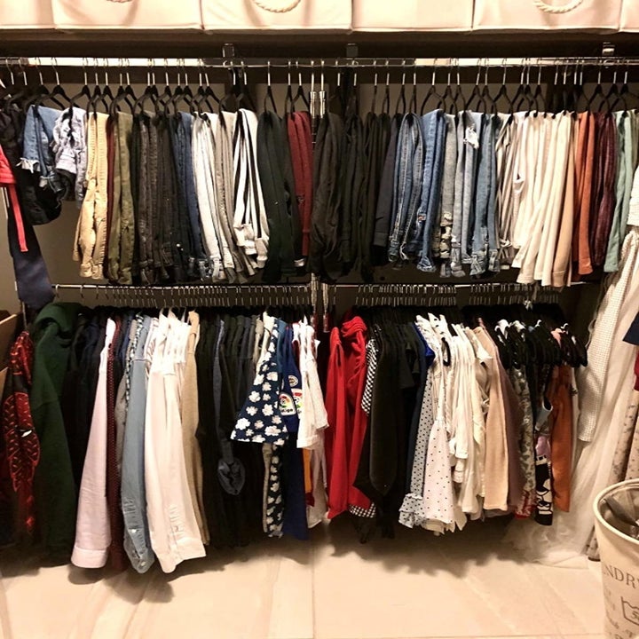 Reviewer uses same adjustable hanging rod to neatly hang up pants, shirts, and other clothes in their closet