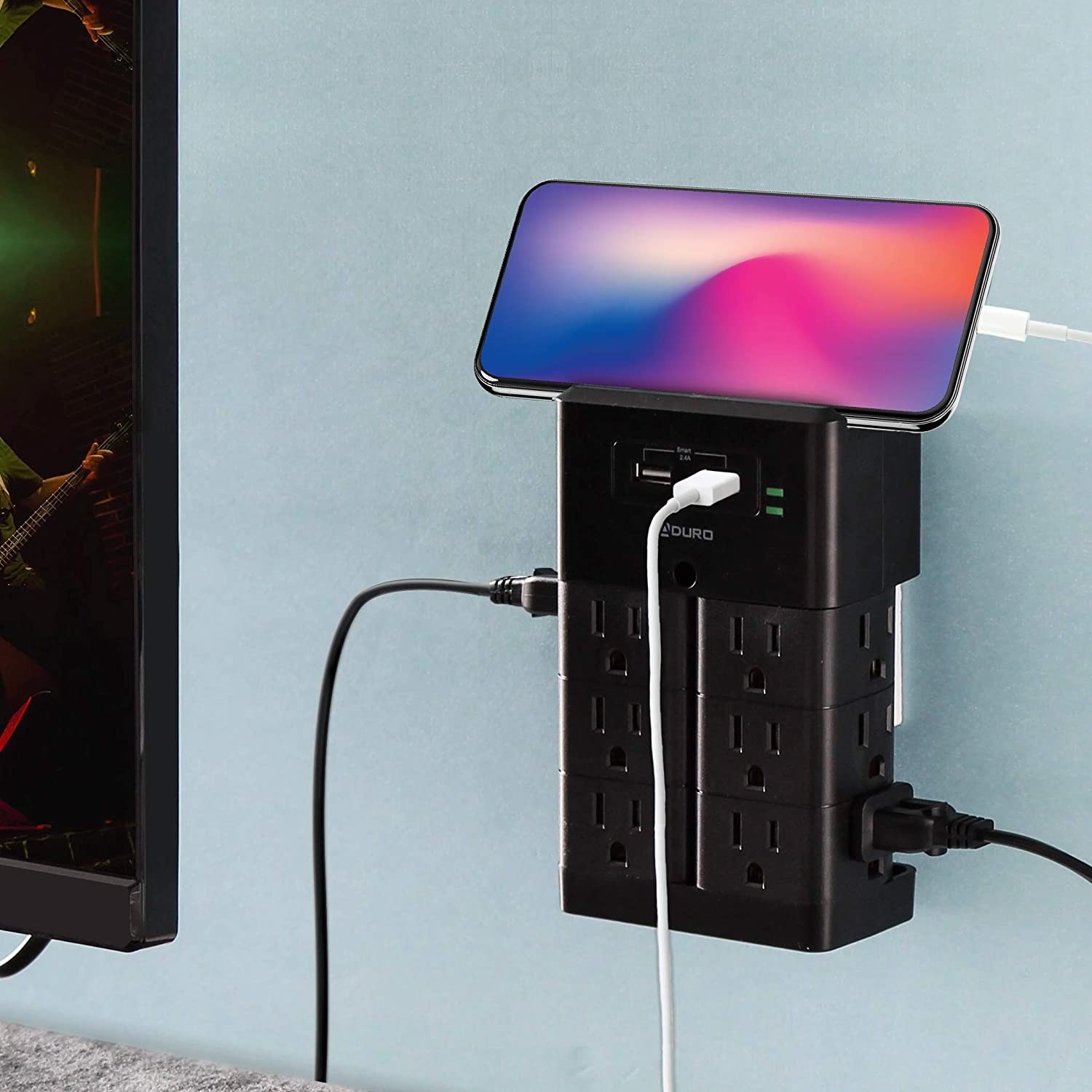 The power bank plugged into a wall next to a computer