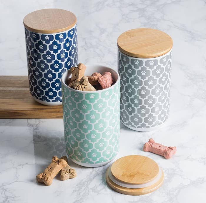 Three ceramic jars with lids and dog treats inside 