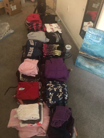 Reviewer's sweatshirts and winter clothes arranged in a line on the floor