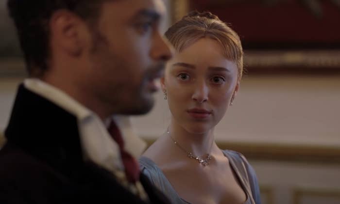 Phoebe Dynevor as Daphne Bridgerton staring at Regé-Jean Page as the Duke of Hastings