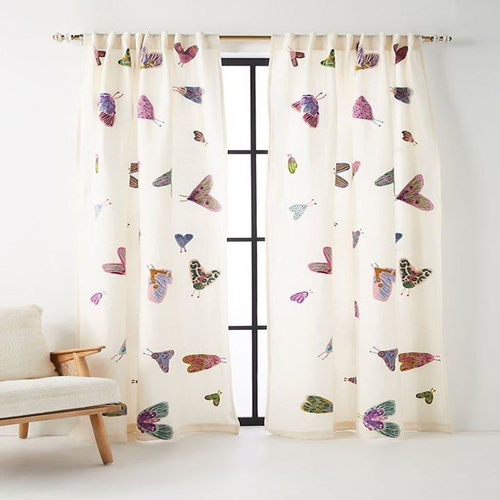 White floor length curtains with multi-colored embroidered butterflies 