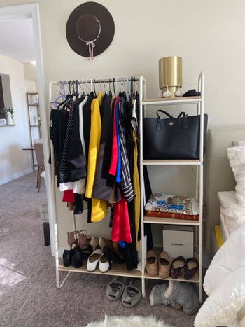 Reviewer uses same garment rack to display wardrobe essentials, including colorful jackets, dresses, and shoes, in their small bedroom
