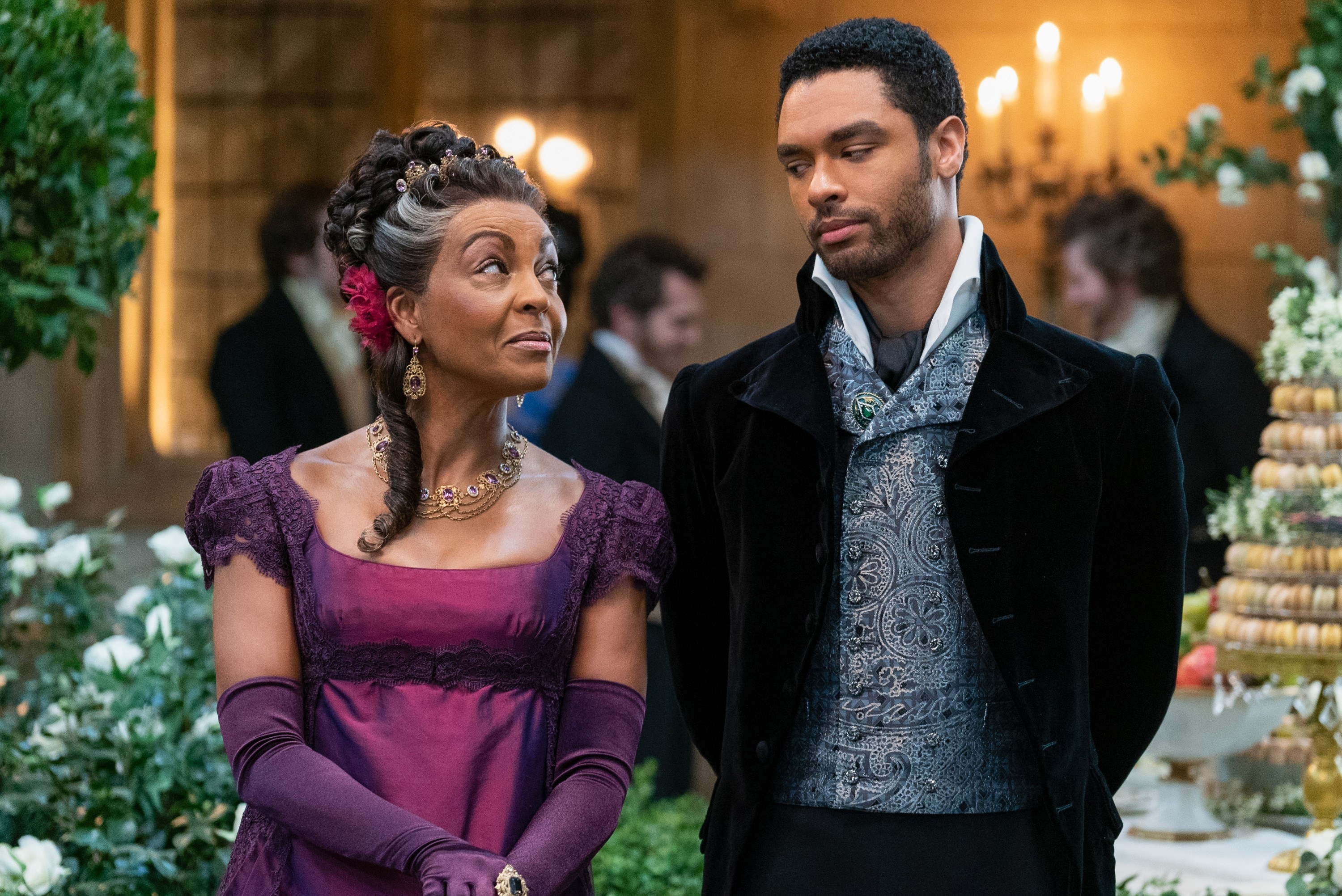 Adjoa Andoh as Lady Danbury and the Duke of Hastings speaking to one another at a ball