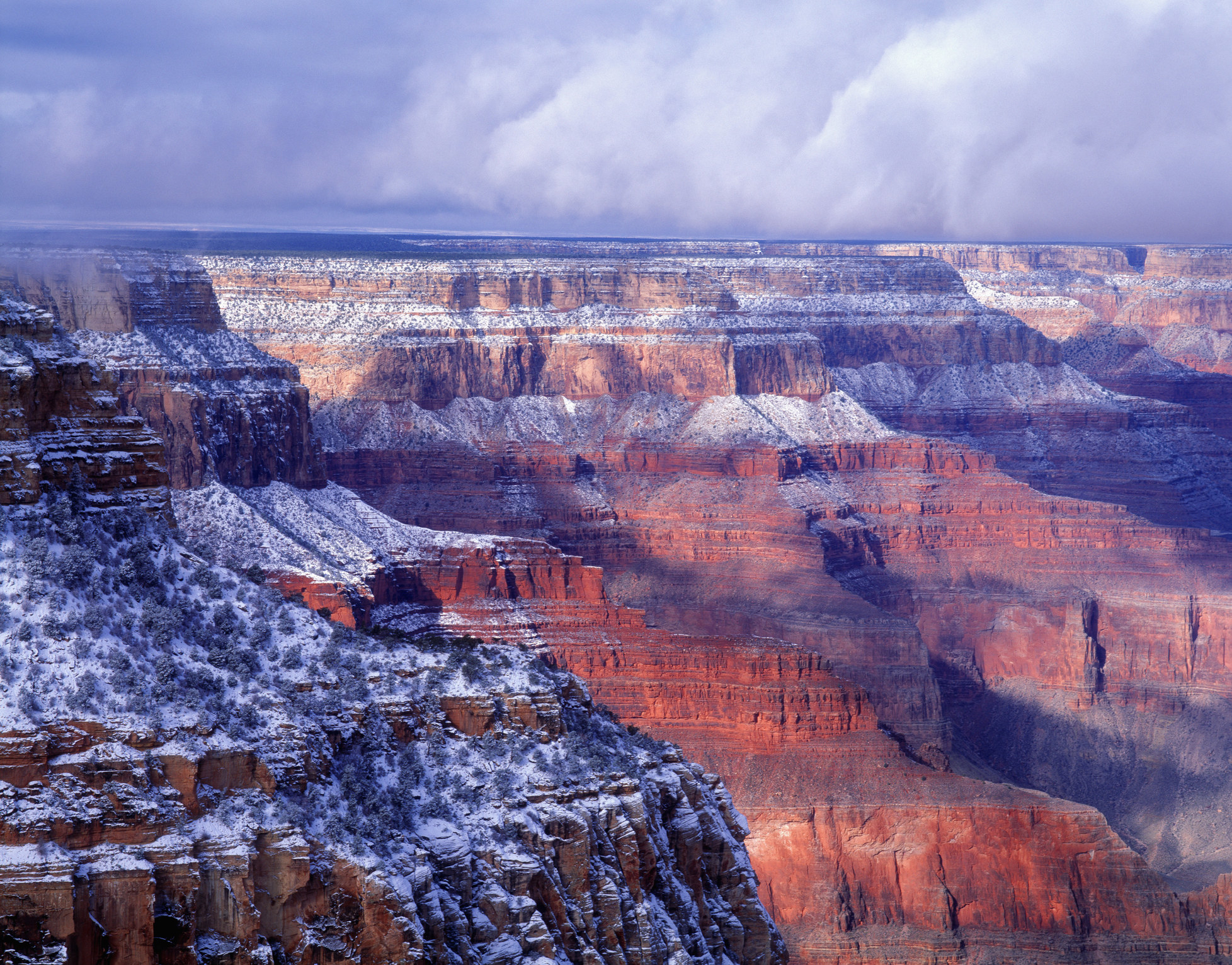 red rocky cliffs of the grand canyon dusted with snow