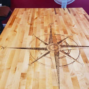 Reviewer's rose compass burned into tabletop 